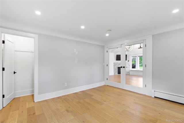 5164 Plymouth Rd, Ann Arbor, MI 48105 - empty room with a baseboard radiator, french doors, light wood-style floors, and recessed lighting