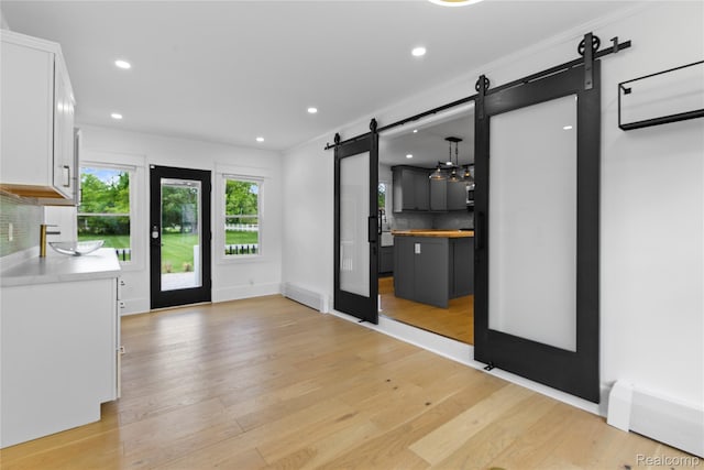 5164 Plymouth Rd, Ann Arbor, MI 48105 - interior space featuring a barn door, light wood finished floors, and recessed lighting