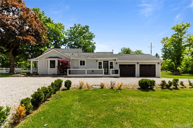 5164 Plymouth Rd, Ann Arbor, MI 48105 - ranch-style house featuring an attached garage, a front lawn, driveway, and a wooden deck