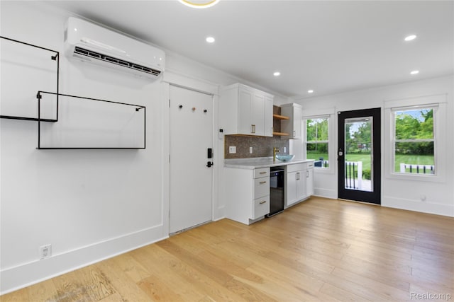 5164 Plymouth Rd, Ann Arbor, MI 48105 - kitchen with an AC wall unit, open shelves, light countertops, white cabinets, and light wood-style floors