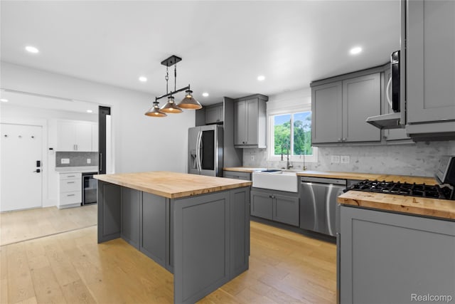5164 Plymouth Rd, Ann Arbor, MI 48105 - kitchen with butcher block countertops, stainless steel appliances, gray cabinets, decorative backsplash, and recessed lighting