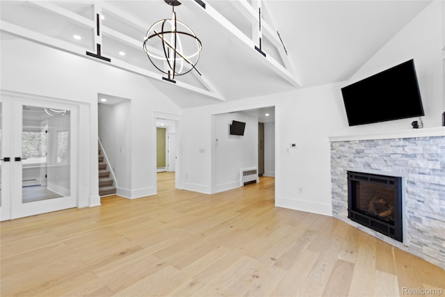 5164 Plymouth Rd, Ann Arbor, MI 48105 - unfurnished living room with light wood-style floors, a stone fireplace, recessed lighting, stairs, and a baseboard heating unit