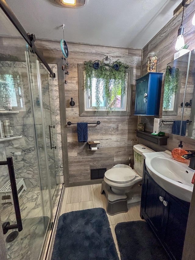 2069 Kenwood Dr, Flint, MI 48532 - bathroom with wooden walls, vanity, toilet, and a stall shower