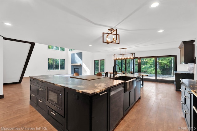 5080 Tootmoor Rd, Bloomfield Hills, MI 48302 - kitchen featuring dishwasher, black microwave, a sink, dark cabinets, and a large island
