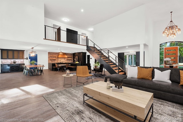 5080 Tootmoor Rd, Bloomfield Hills, MI 48302 - living room featuring a towering ceiling, wood finished floors, stairs, plenty of natural light, and a chandelier