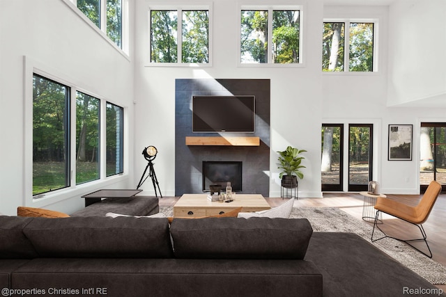 5080 Tootmoor Rd, Bloomfield Hills, MI 48302 - living room featuring a towering ceiling, a glass covered fireplace, healthy amount of natural light, and wood finished floors