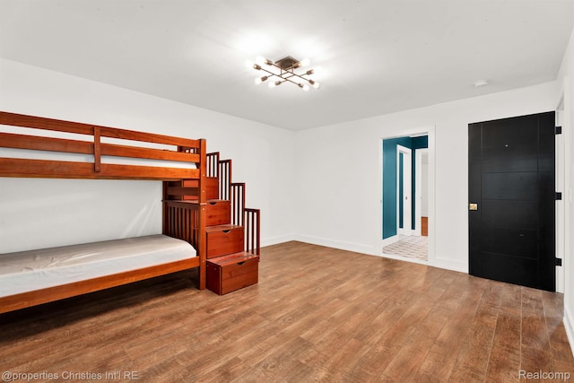 5080 Tootmoor Rd, Bloomfield Hills, MI 48302 - unfurnished bedroom with wood finished floors, baseboards, and a chandelier
