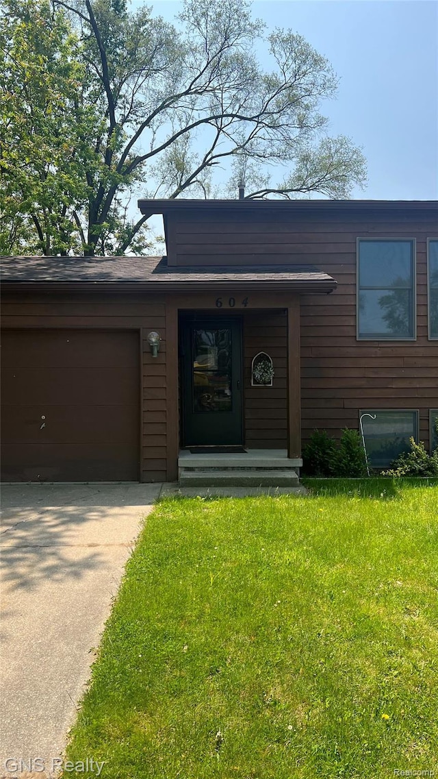 604 Millard Ave, Royal Oak, MI 48073 - property entrance featuring concrete driveway, an attached garage, and a lawn