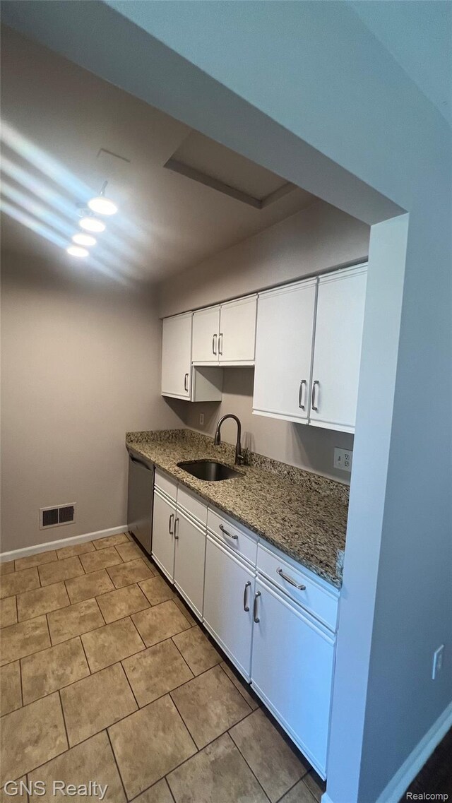 604 Millard Ave, Royal Oak, MI 48073 - kitchen featuring stainless steel dishwasher, a sink, white cabinets, baseboards, and stone counters
