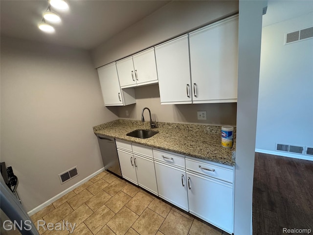 604 Millard Ave, Royal Oak, MI 48073 - kitchen featuring dishwasher, a sink, baseboards, and white cabinets