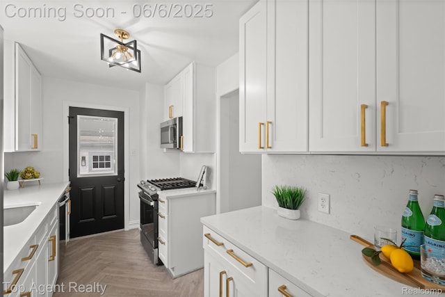 1703 N Blair Ave, Royal Oak, MI 48067 - kitchen with appliances with stainless steel finishes, white cabinetry, light stone counters, and tasteful backsplash