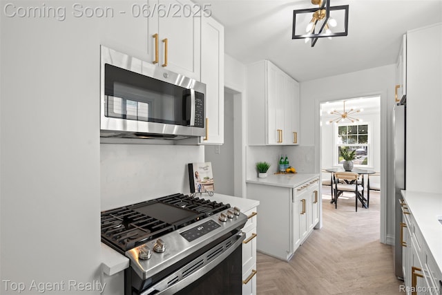 1703 N Blair Ave, Royal Oak, MI 48067 - kitchen with stainless steel appliances, a chandelier, light countertops, and white cabinets