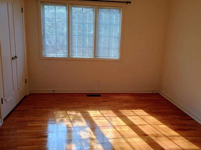 1635 Woodside Dr, East Lansing, MI 48823 - unfurnished room with wood finished floors, plenty of natural light, and baseboards