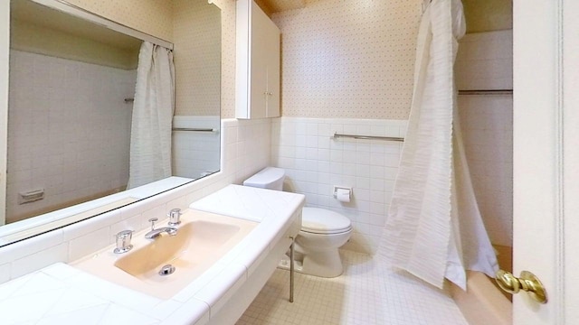 1635 Woodside Dr, East Lansing, MI 48823 - bathroom with wallpapered walls, tile walls, toilet, wainscoting, and curtained shower