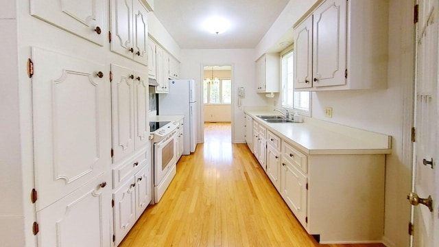 1635 Woodside Dr, East Lansing, MI 48823 - kitchen featuring white appliances, a sink, light countertops, and light wood-style flooring
