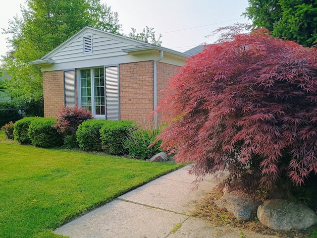 1635 Woodside Dr, East Lansing, MI 48823 - view of home's exterior with brick siding and a lawn