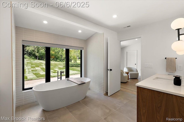 4340 Charing Cross Rd, Bloomfield Hills, MI 48304 - full bath with a freestanding tub, vanity, recessed lighting, tile patterned floors, and vaulted ceiling
