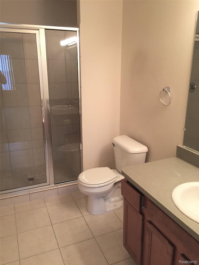 49225 W Woods Dr Unit 20, Utica, MI 48317 - bathroom featuring vanity, a stall shower, toilet, and tile patterned floors
