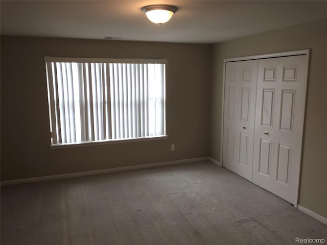 49225 W Woods Dr Unit 20, Utica, MI 48317 - unfurnished bedroom featuring baseboards, carpet floors, and a closet