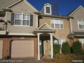 49225 W Woods Dr Unit 20, Utica, MI 48317 - view of property with an attached garage and brick siding