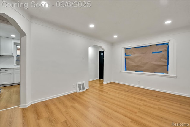 9248 Manor St, Detroit, MI 48204 - empty room featuring arched walkways, light wood finished floors, recessed lighting, and baseboards