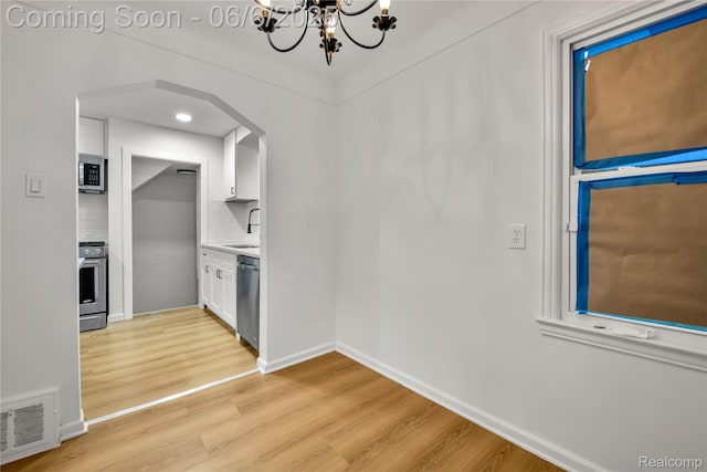 9248 Manor St, Detroit, MI 48204 - unfurnished dining area featuring a chandelier, light wood-type flooring, baseboards, a sink, and recessed lighting