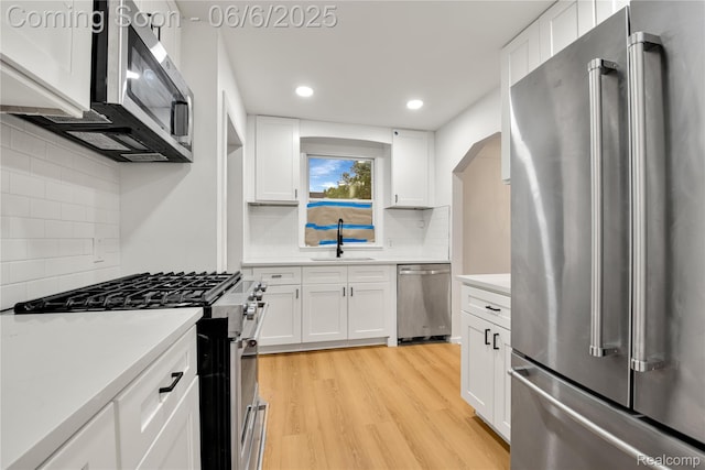 9248 Manor St, Detroit, MI 48204 - kitchen featuring appliances with stainless steel finishes, a sink, backsplash, light wood finished floors, and recessed lighting