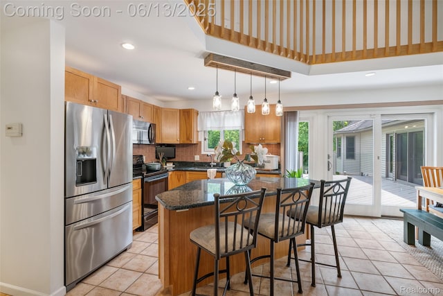 4230 Mill Lake Rd, Lake Orion, MI 48360 - kitchen with black appliances, decorative backsplash, a breakfast bar area, a center island, and light tile patterned floors