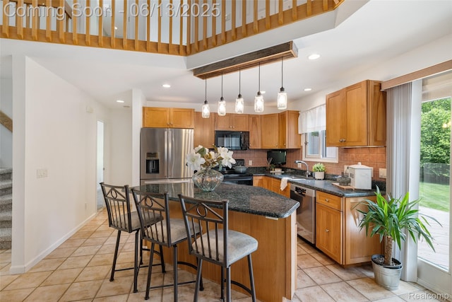 4230 Mill Lake Rd, Lake Orion, MI 48360 - kitchen with black appliances, backsplash, a kitchen breakfast bar, a center island, and light tile patterned floors