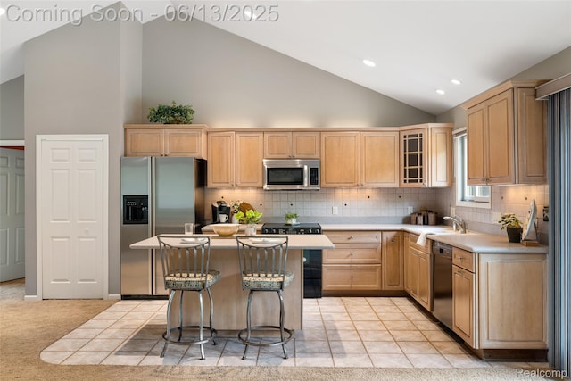 4230 Mill Lake Rd, Lake Orion, MI 48360 - kitchen featuring stainless steel appliances, light brown cabinets, a breakfast bar area, glass insert cabinets, and light countertops