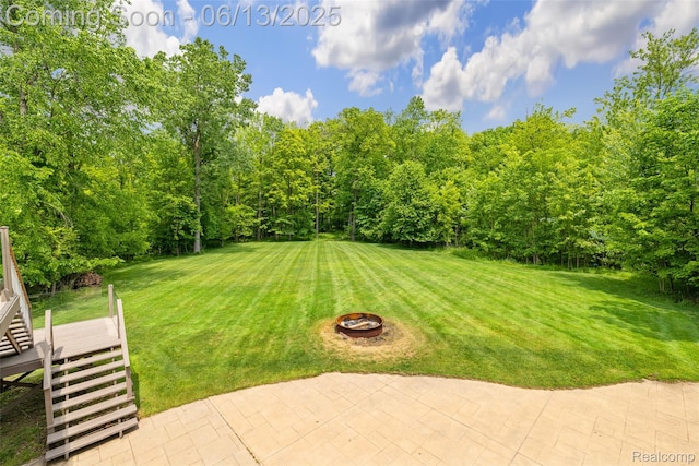 4230 Mill Lake Rd, Lake Orion, MI 48360 - view of green lawn with stairway, an outdoor fire pit, a deck, and a patio