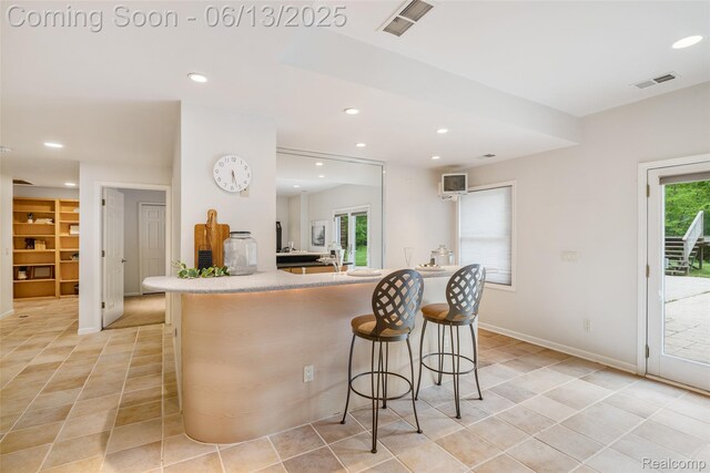 4230 Mill Lake Rd, Lake Orion, MI 48360 - kitchen featuring light tile patterned floors, recessed lighting, a kitchen breakfast bar, built in shelves, and light countertops
