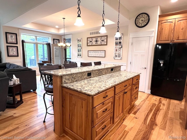 4264 W Benjamin Rd, Perry, MI 48872 - kitchen with black fridge, a kitchen bar, light wood-type flooring, a kitchen island, and recessed lighting