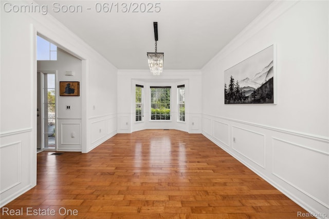 3788 High Grove Way, Lake Orion, MI 48360 - unfurnished dining area with ornamental molding, a chandelier, light wood finished floors, a decorative wall, and a wainscoted wall