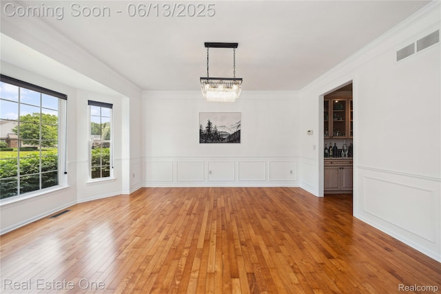3788 High Grove Way, Lake Orion, MI 48360 - unfurnished dining area featuring a chandelier, light wood-style flooring, crown molding, and wainscoting