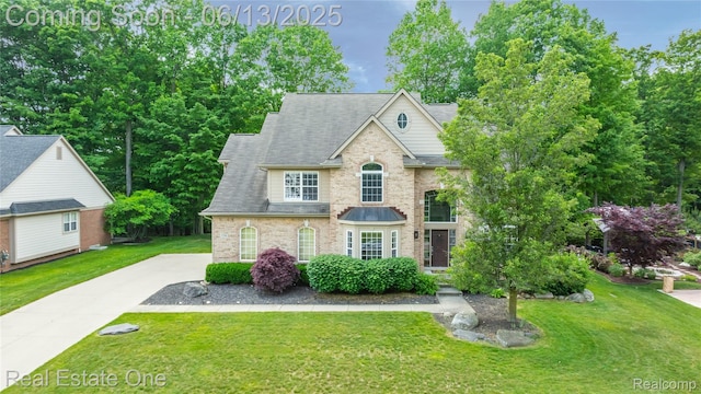 3788 High Grove Way, Lake Orion, MI 48360 - traditional home featuring a front yard, a shingled roof, concrete driveway, and brick siding