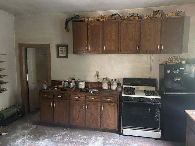 342 Grand St, Michigan Center, MI 49254 - kitchen with range with gas stovetop, freestanding refrigerator, and concrete floors