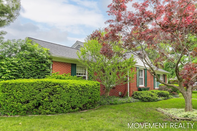 1001 Cricklewood St SW, Wyoming, MI 49509 - view of front of property with brick siding, a front lawn, and roof with shingles