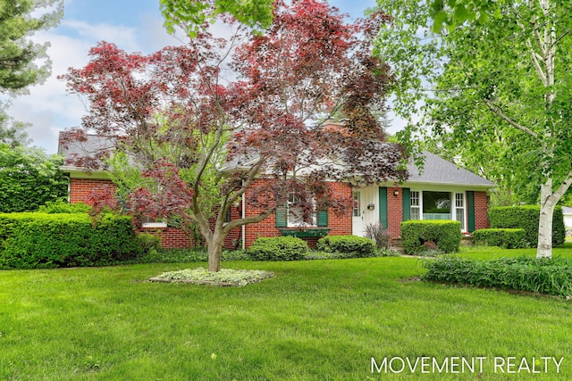 1001 Cricklewood St SW, Wyoming, MI 49509 - view of front of property with brick siding, a front yard, and roof with shingles