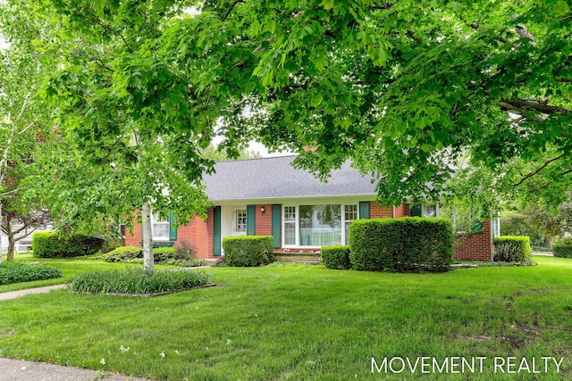 1001 Cricklewood St SW, Wyoming, MI 49509 - view of front of house featuring brick siding, a front yard, and a shingled roof