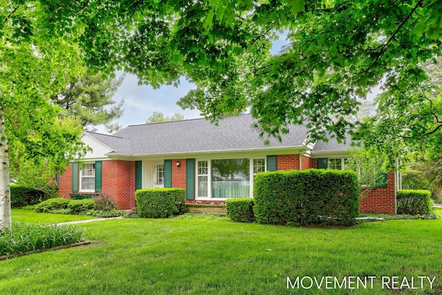 1001 Cricklewood St SW, Wyoming, MI 49509 - view of front of house with brick siding, a front lawn, and roof with shingles