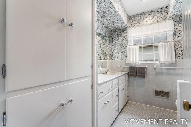 1001 Cricklewood St SW, Wyoming, MI 49509 - bathroom with vanity, tile patterned floors, and tile walls