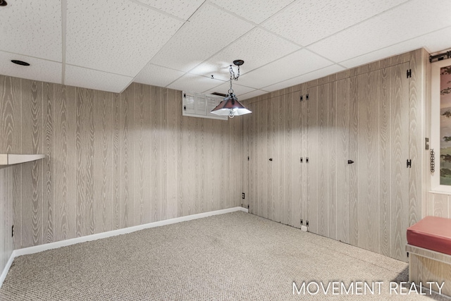 1001 Cricklewood St SW, Wyoming, MI 49509 - unfurnished dining area featuring a drop ceiling, carpet, and wood walls