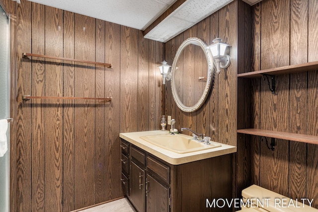 1001 Cricklewood St SW, Wyoming, MI 49509 - bathroom featuring wood walls, vanity, and toilet