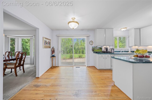 2105 Rob Rdg, Commerce Twp, MI 48390 - kitchen with dark countertops, white cabinets, light wood-style flooring, and a sink