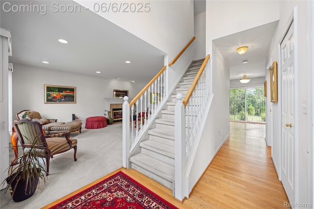 2105 Rob Rdg, Commerce Twp, MI 48390 - stairway with wood finished floors, a glass covered fireplace, and recessed lighting