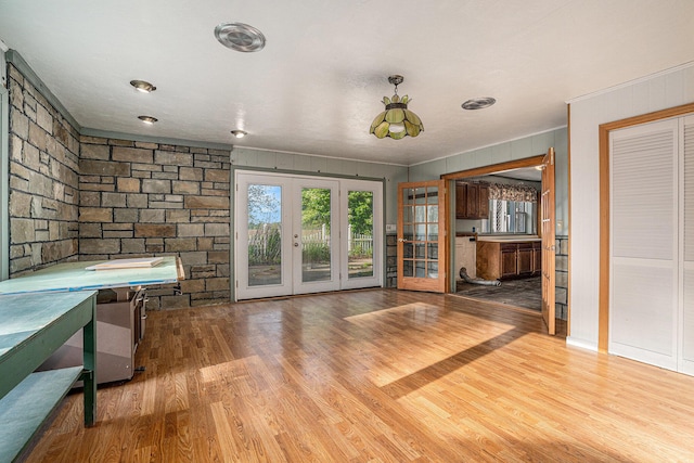 19146 Fairchild Rd, Constantine, MI 49042 - unfurnished living room featuring wood finished floors, french doors, and ornamental molding