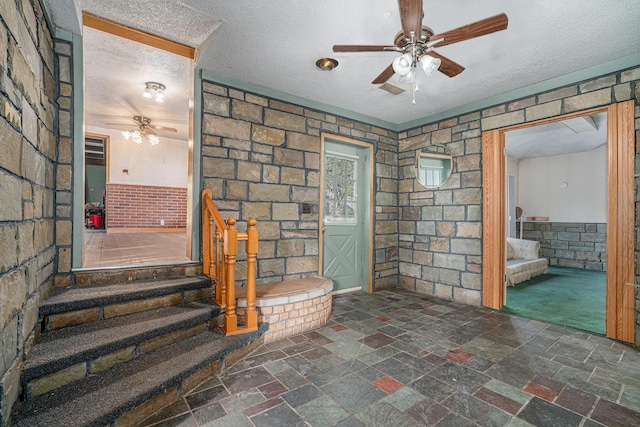 19146 Fairchild Rd, Constantine, MI 49042 - unfurnished living room with a ceiling fan, stone tile floors, a textured ceiling, and stairs