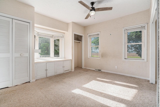19146 Fairchild Rd, Constantine, MI 49042 - unfurnished bedroom with two closets, light carpet, baseboards, and a ceiling fan