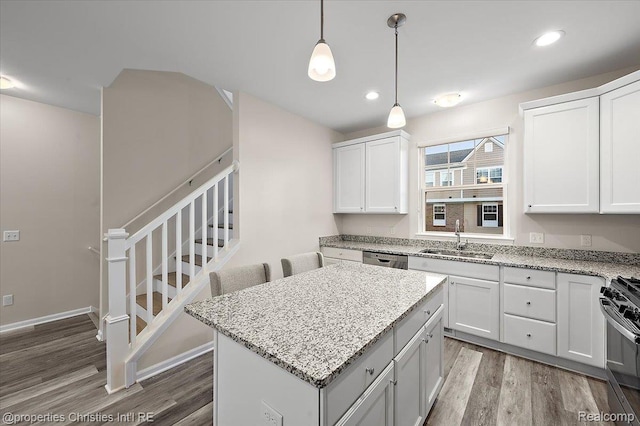 4953 Treeside Ln, Troy, MI 48098 - kitchen with wood finished floors, appliances with stainless steel finishes, a kitchen island, recessed lighting, and white cabinetry